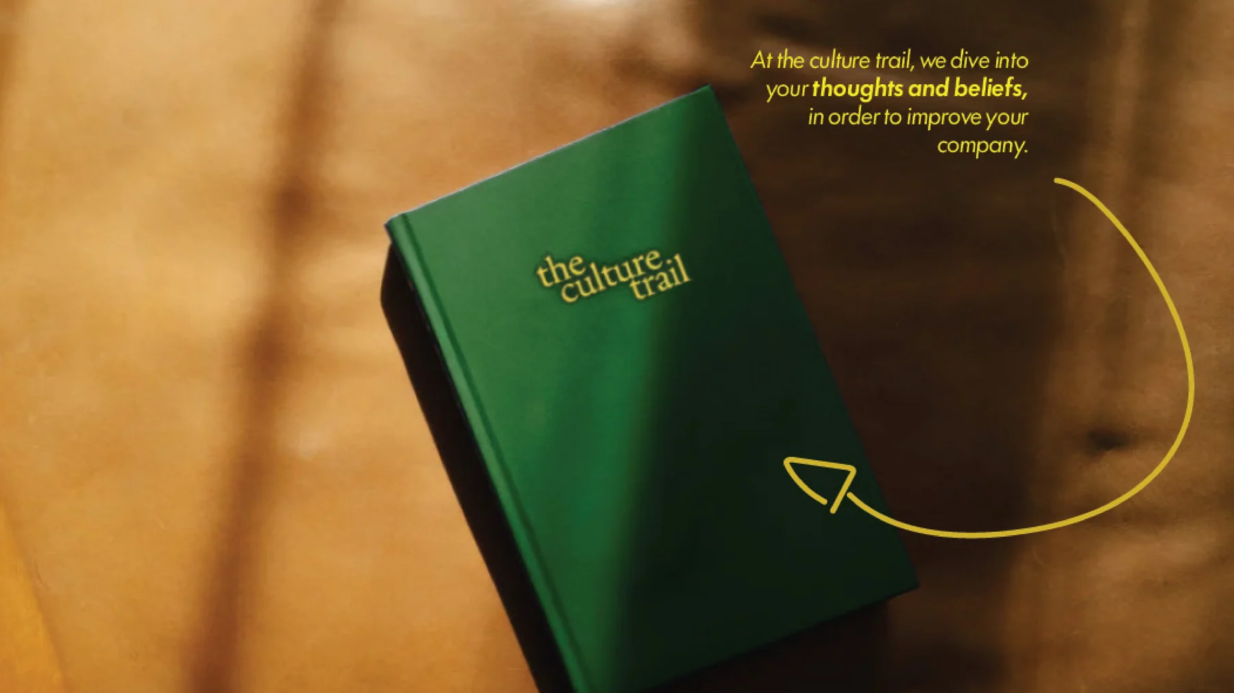 Het donkergroene trailboek met de wordmark in goudfolie, warm tegenlicht