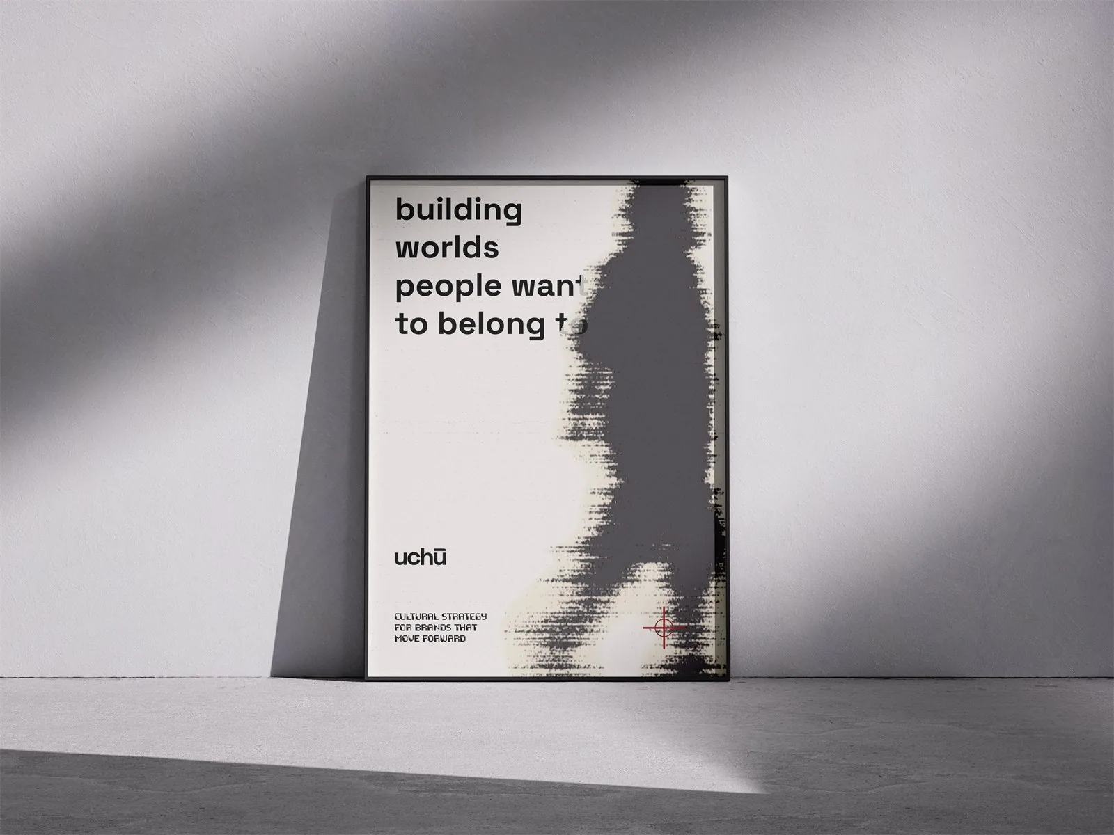 Een ingelijste poster tegen een betonnen muur: building worlds people want to belong to, met een lopend silhouet in halftone